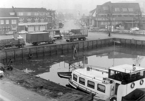 De Belcrumhaven met zicht op de Belcrumweg richting stad. Aan de kade vrachtwagens van Stoof. | Foto: collectie Stadsarchief Breda